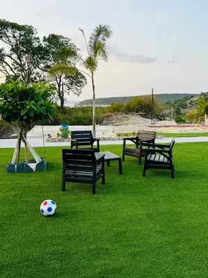 a soccer ball sitting on the grass with benches at Sundown Relaxed in Punta Rucia