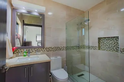 a bathroom with a toilet and a glass shower at Beautiful villa in the Caribbean! in Sosúa