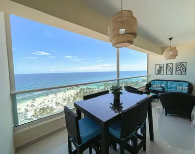 a dining room with a table and a view of the ocean at Acogedor Apartamento con Vista al mar in Juan Dolio
