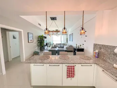 a kitchen with a counter and a dining room at Acogedor Apartamento con Vista al mar in Juan Dolio