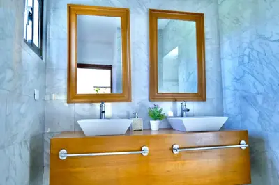 two sinks in a bathroom with two mirrors at Villa Pravda Paradise Guerra in La Caoba