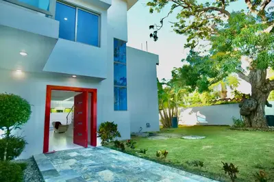 a house with a red door and a yard at Villa Pravda Paradise Guerra in La Caoba