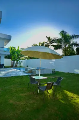 a table and chairs with an umbrella next to a pool at Villa Pravda Paradise Guerra in La Caoba