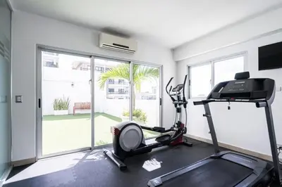 a room with a gym with a treadmill and a window at Armonia 17 suites by Yellowkey in Santo Domingo