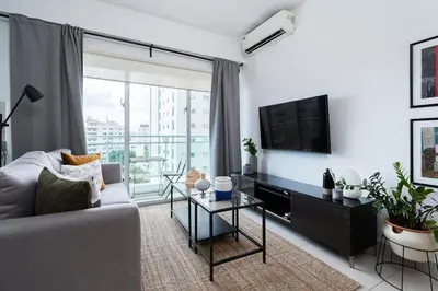 a living room with a couch and a flat screen tv at Armonia 17 suites by Yellowkey in Santo Domingo