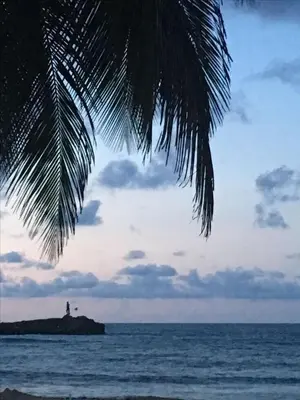 a lighthouse on a small island in the ocean at Marbella in San Felipe de Puerto Plata