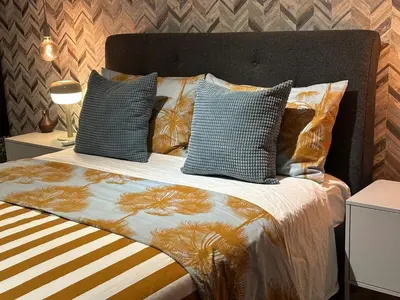 a bed with several pillows on top of it at Acogedor Penthouse de 2 habitación in Santiago de los Caballeros