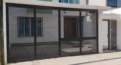a garage door with a black gate on a building at Punta cana in El Seis