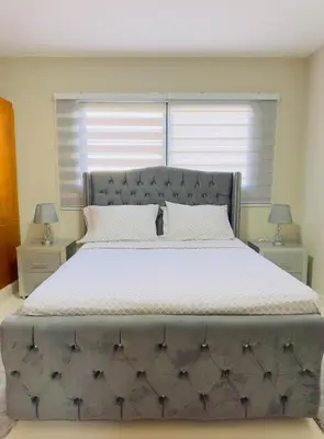 a large bed in a bedroom with two night stands at Excelente Apartamento Completo Renta Carro Disponible in La Viva