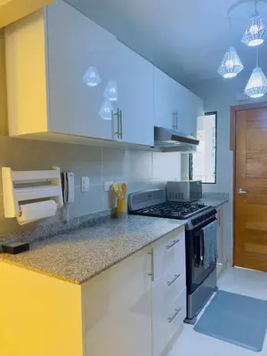 a kitchen with white cabinets and a stove top oven at Excelente Apartamento Completo Renta Carro Disponible in La Viva