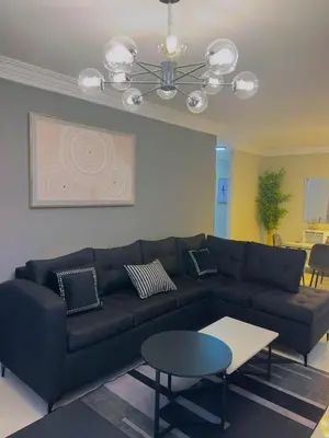 a living room with a black couch and a table at Excelente Apartamento Completo Renta Carro Disponible in La Viva