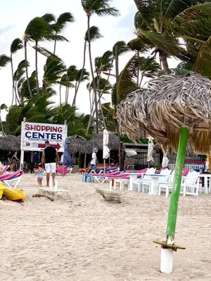 a sign on a beach with chairs and palm trees at Cocotal 2beds apartament Golf Course Melia Beach PC RD in Punta Cana