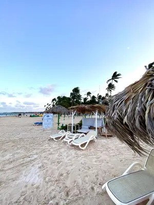 a group of chairs and umbrellas on a beach at Cocotal 2beds apartament Golf Course Melia Beach PC RD in Punta Cana
