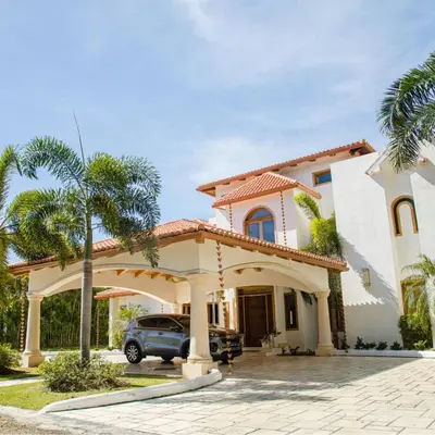 a house with a car parked in front of it at Villa at Metro Country Club in Juan Dolio