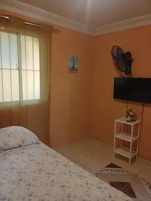 a bedroom with a bed and a flat screen tv at Dona Beba Guesthouse in La Caleta