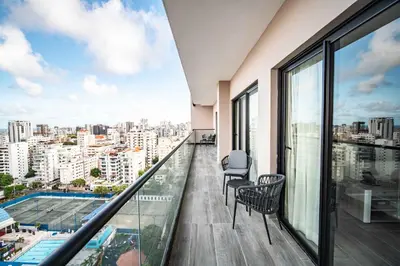 a balcony with chairs and a view of a city at Aston Rubi City Suites in Santo Domingo