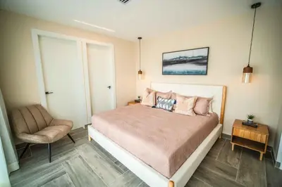 a bedroom with a large bed and a chair at Aston Rubi City Suites in Santo Domingo