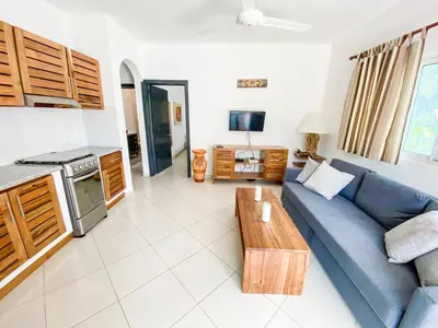 a living room with a blue couch and a table at la fenice un apartamento de ensueño en Las Terrenas playa Punta Popy in Las Terrenas