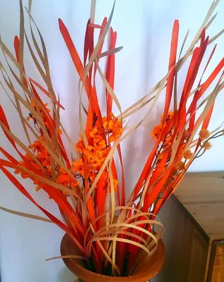 a vase filled with orange flowers and grass at la fenice un apartamento de ensueño en Las Terrenas playa Punta Popy in Las Terrenas