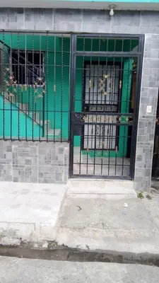 a green door with bars on a building at Chez Guela in Mandinga