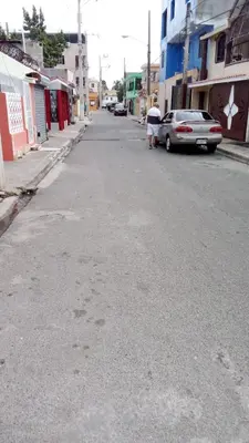 an empty street in a town with cars parked at Chez Guela in Mandinga