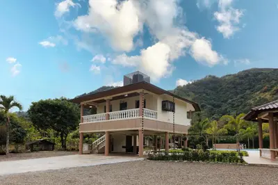 a house with a balcony and a mountain in the background at Rancho Don Pedro in Bonao