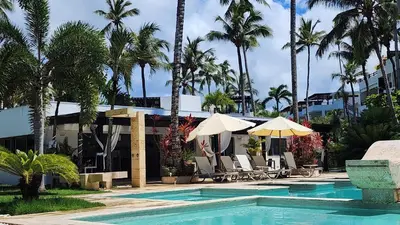 a swimming pool with chairs and umbrellas next to a building at Aligio - A Quiet Retreat in Paradise - 2 BR, 2 pools, WiFi, AC, Private Hot Tub in Las Terrenas