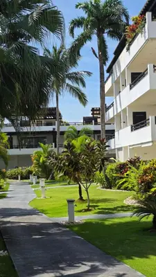 a walkway in front of a building with palm trees at Aligio - A Quiet Retreat in Paradise - 2 BR, 2 pools, WiFi, AC, Private Hot Tub in Las Terrenas