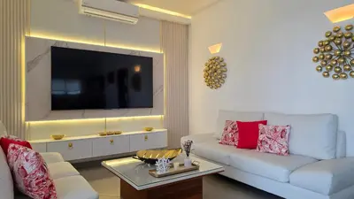 a living room with a white couch and a tv at Aligio - A Quiet Retreat in Paradise - 2 BR, 2 pools, WiFi, AC, Private Hot Tub in Las Terrenas