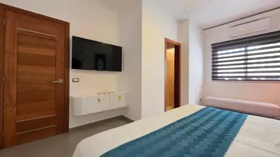 a bedroom with a bed and a flat screen tv at Aligio - A Quiet Retreat in Paradise - 2 BR, 2 pools, WiFi, AC, Private Hot Tub in Las Terrenas
