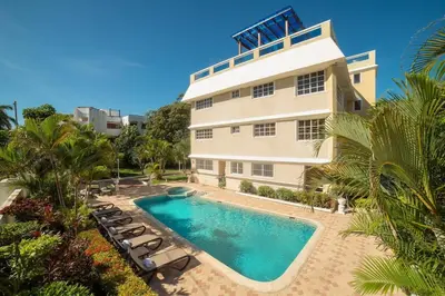 a building with a swimming pool in front of a building at Reina del Mar 5 in Cafemba