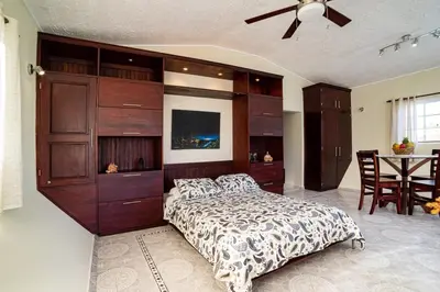 a bedroom with a large bed and a table at Reina del Mar 5 in Cafemba