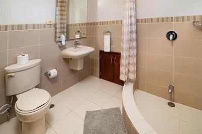 a bathroom with a toilet and a sink at Reina del Mar 5 in Cafemba