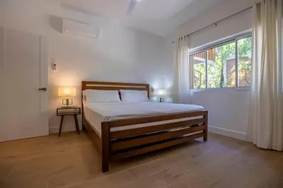 a bedroom with a bed and a large window at Perla Marina Beachside Apartment in Bombita