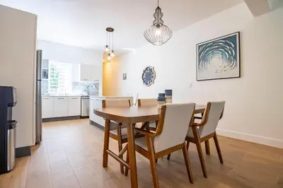 a kitchen and dining room with a table and chairs at Perla Marina Beachside Apartment in Bombita