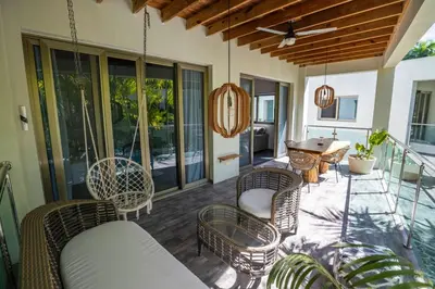 a porch with rattan furniture and a table and chairs at ProCab Kaya Apartments Cabarete in Cabarete