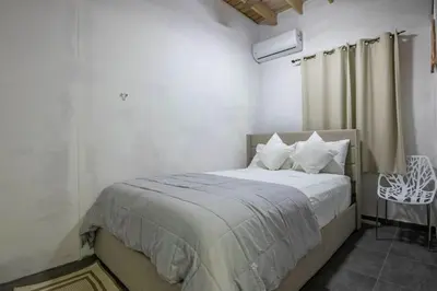 a bedroom with a bed and a chair in it at ProCab Kaya Apartments Cabarete in Cabarete