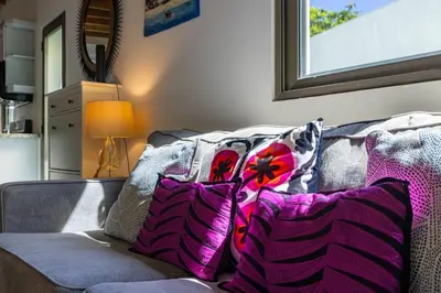 a couch with pillows on it in a living room at ProCab Kaya Apartments Cabarete in Cabarete