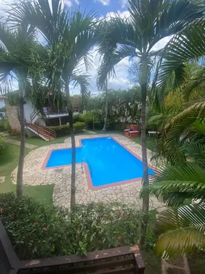 a swimming pool in a yard with palm trees at Beach Cabin Juan Dolio in Villas del Mar