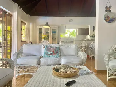 a living room with a couch and a kitchen at Beach Cabin Juan Dolio in Villas del Mar