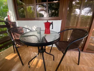 a glass table with two chairs and a red pitcher on it at Beach Cabin Juan Dolio in Villas del Mar