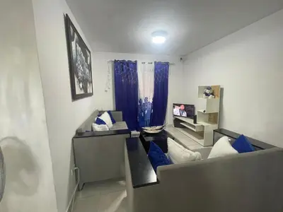 a living room with blue pillows and a couch at Apartamento en Edificio Palmares in La Romana