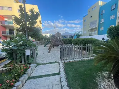 a garden with a wooden fence and a playground at Apartamento en Edificio Palmares in La Romana