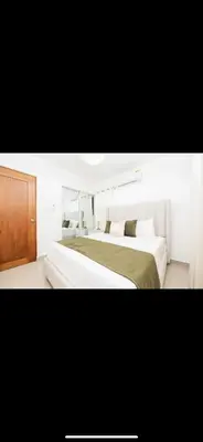 a bedroom with two beds and a wooden cabinet at Blue Lux in Santiago de los Caballeros