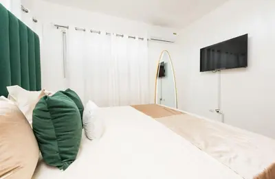 a bedroom with a bed with a tv on the wall at Blue Lux in Santiago de los Caballeros