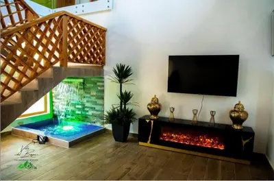 a living room with a fireplace and a tv at Villa del Bosque, Vacacional Matua in La Piña