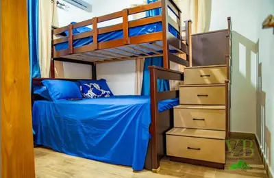 a bedroom with bunk beds with blue sheets and a bed at Villa del Bosque, Vacacional Matua in La Piña