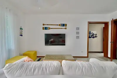a living room with two white couches and a fireplace at Oceanfront Apt W- Private Beach - Las Terrenas in El Limón