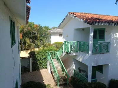 a white building with green railings and a staircase at Cozy studio- centre - near beach in Las Terrenas