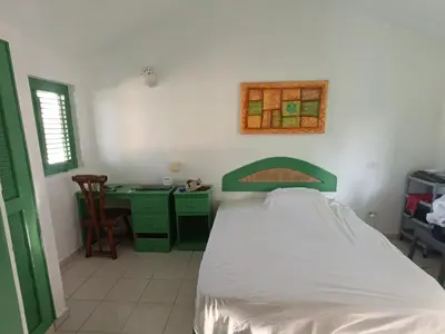 a bedroom with a bed and a desk with a window at Cozy studio- centre - near beach in Las Terrenas